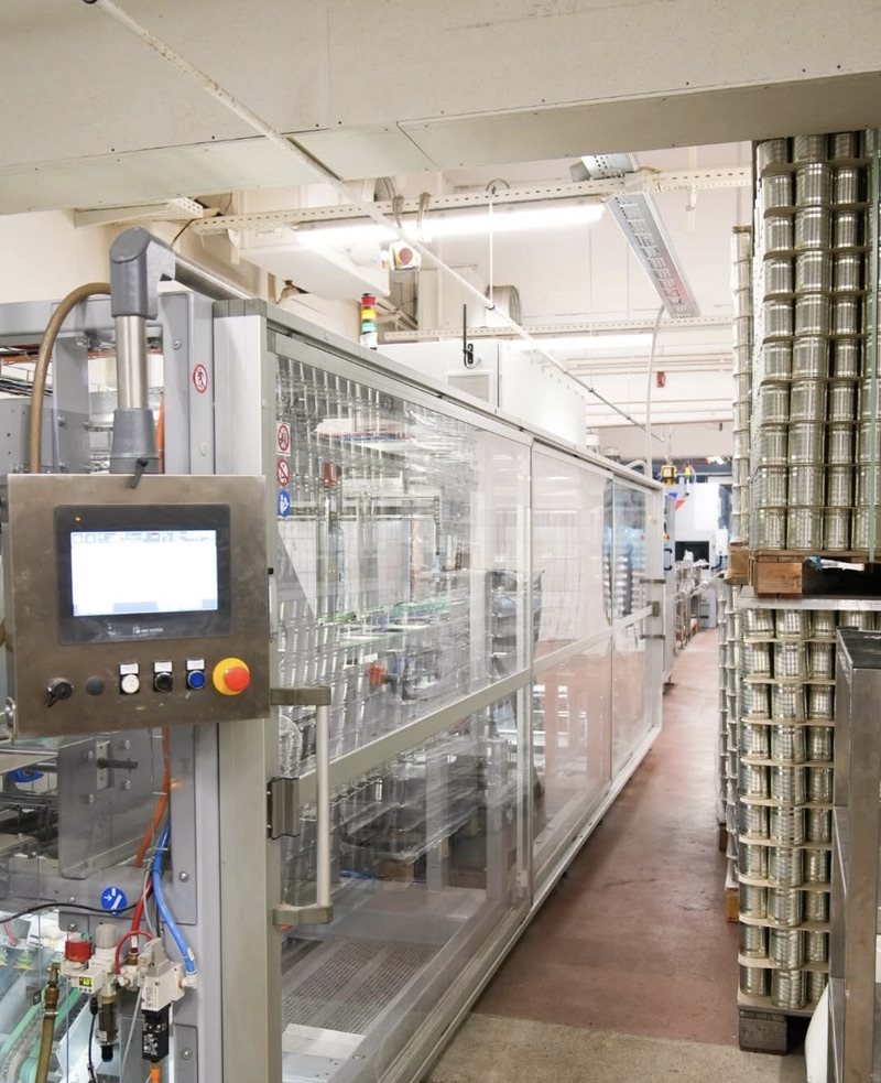 Produktionshalle mit gestapelten Dosen